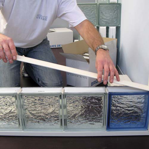 pose profil long sur rangée de briques de verre